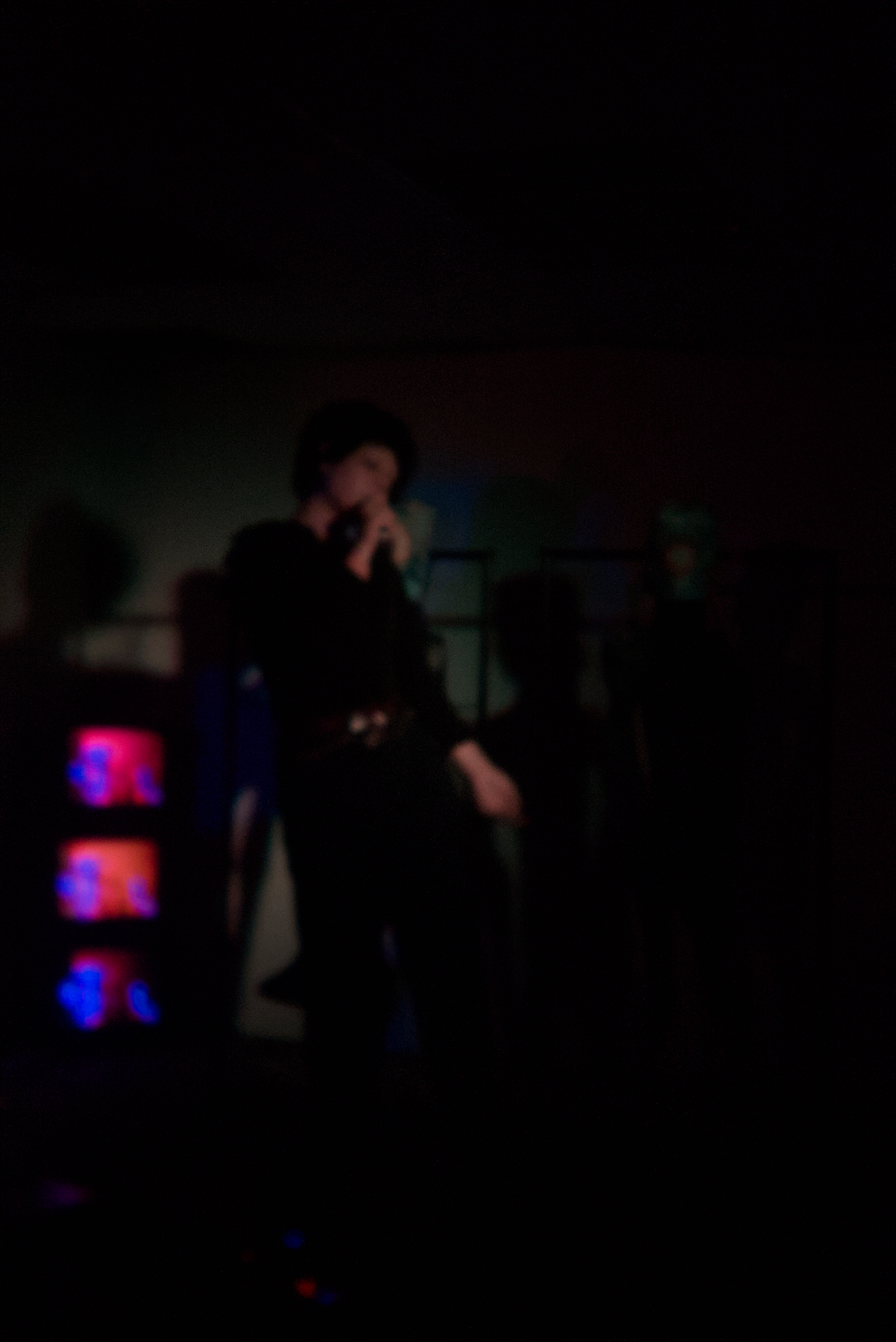 Vocalist beside glowing CRT screens